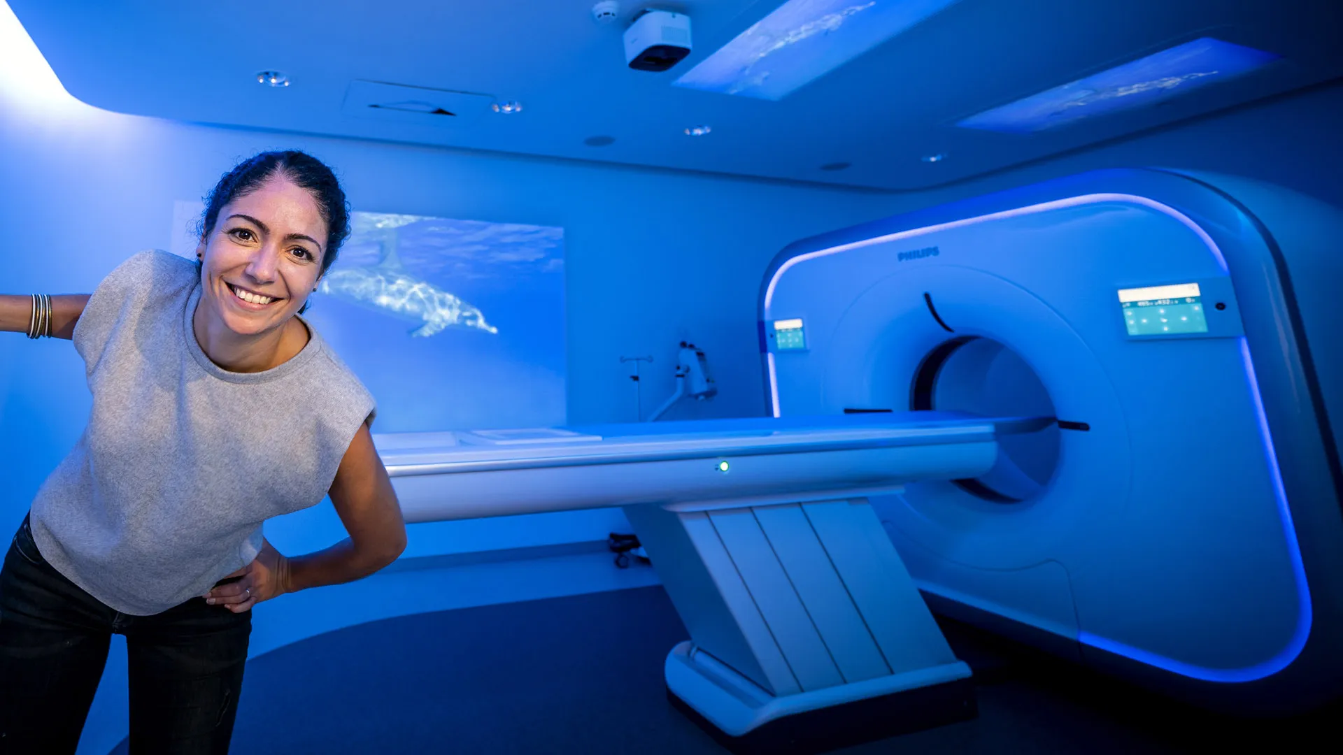 Woman smiling in front of Philips MRI scanner